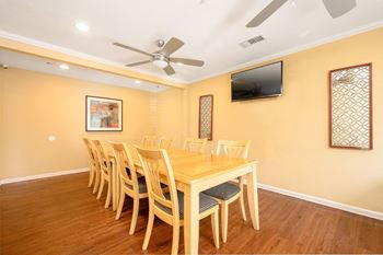 a dining room with a table and chairs and a flat screen tv at Sagewood Gardens Senior Apartments, Hacienda Heights, CA 91745